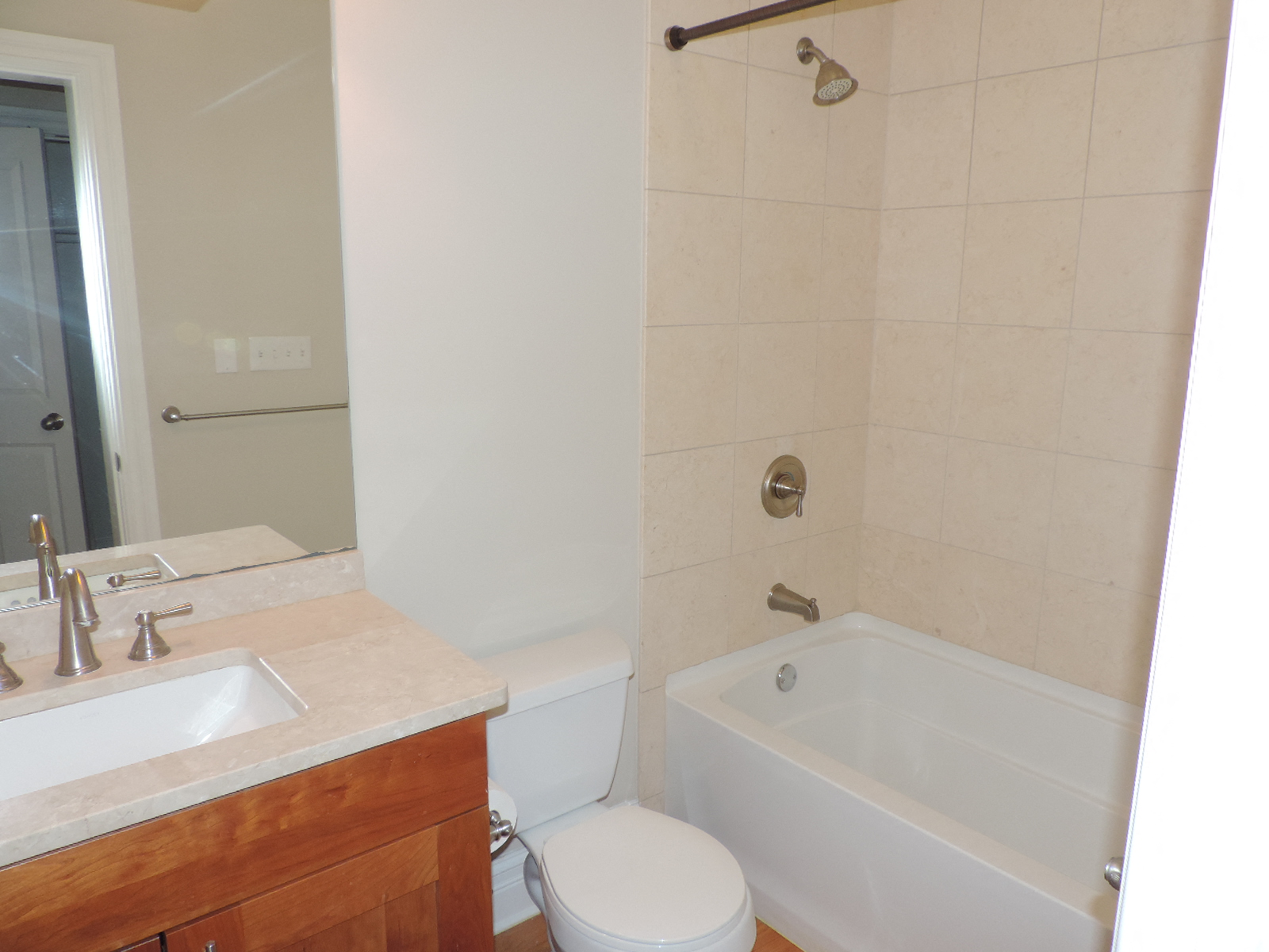 a bathroom with a tub sink and toilet and a mirror