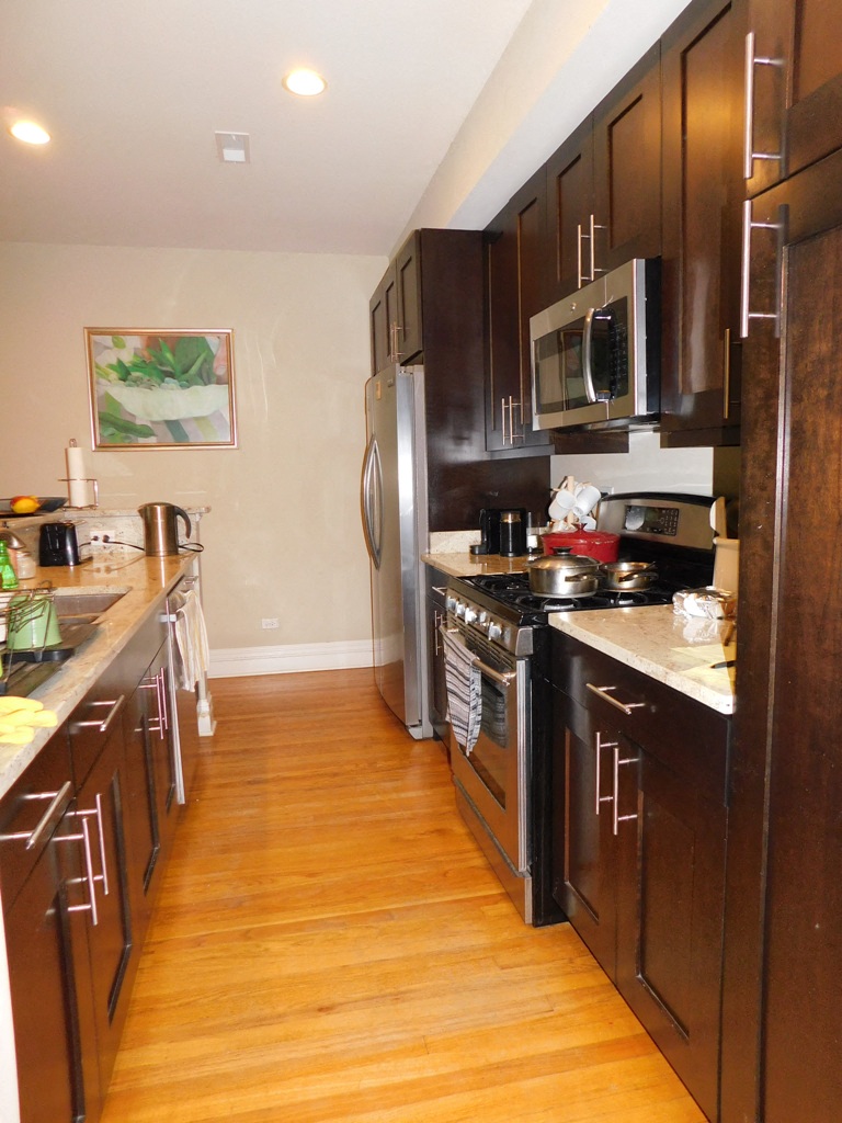 a kitchen with wooden floors and stainless steel appliances