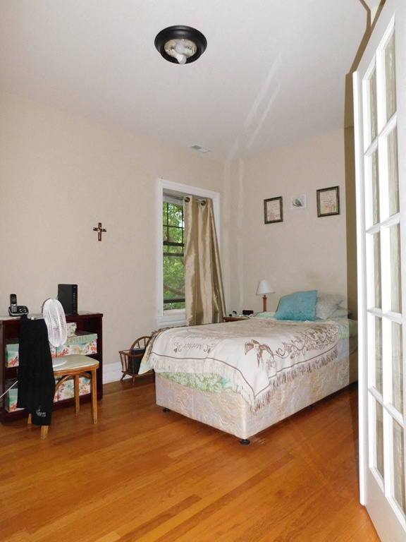 a bedroom with a bed and a wooden floor