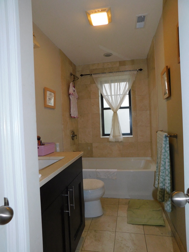 a bathroom with a toilet and a tub and a window