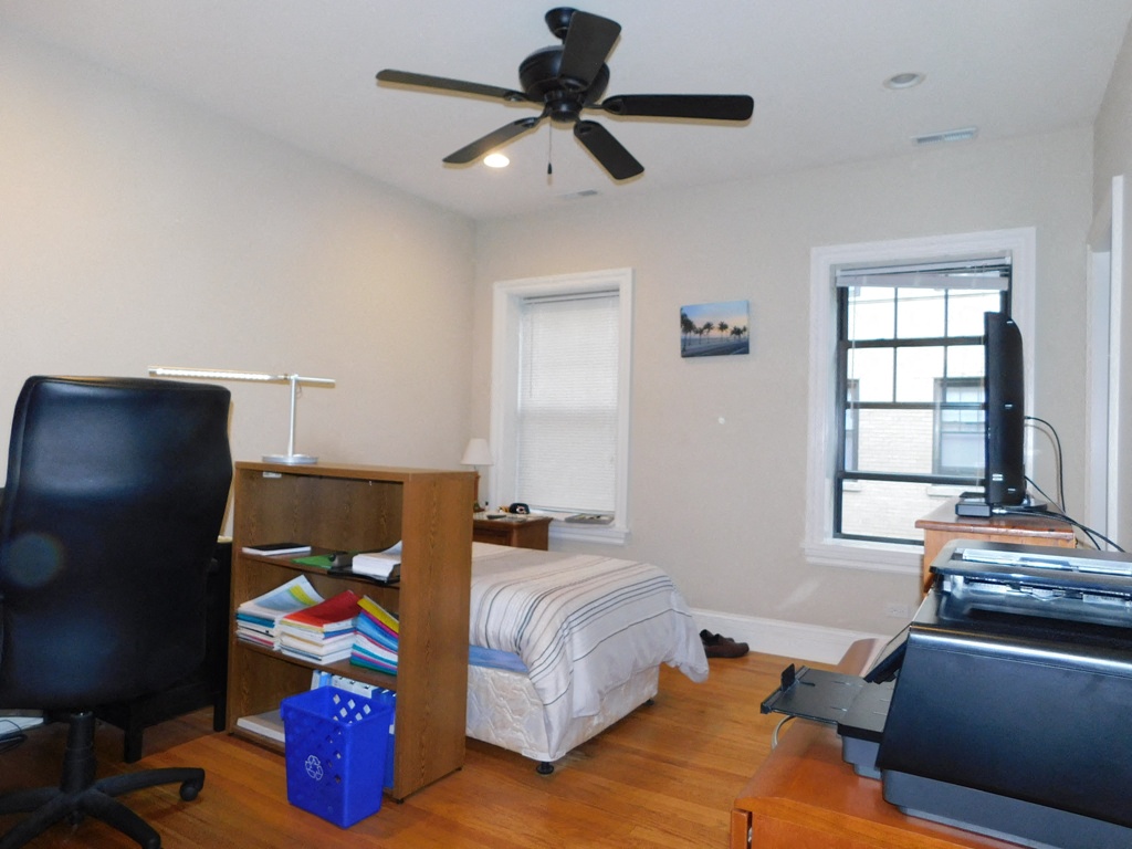 a bedroom with a bed and a ceiling fan and a tv