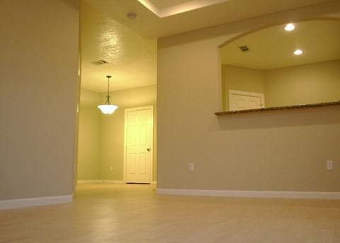 A room with a door and a mirror on the wall.