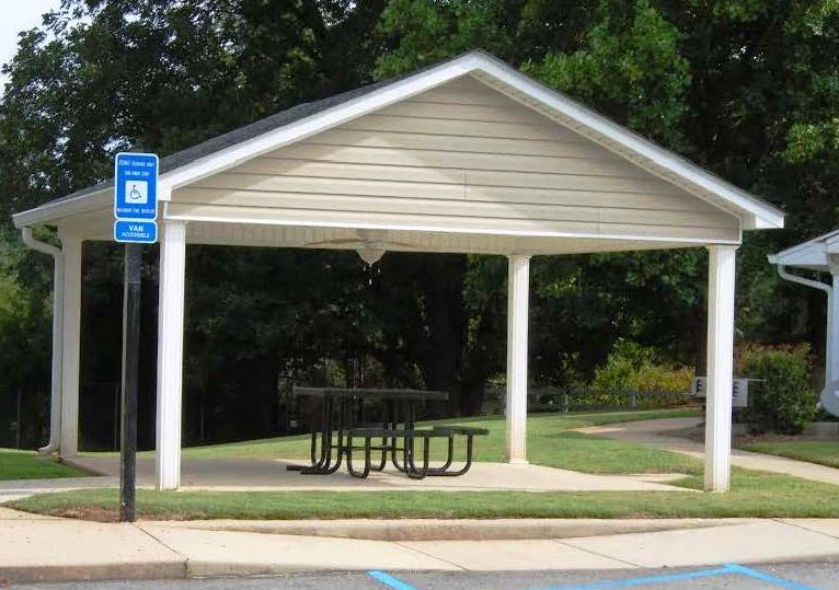 A covered picnic area with a sign on a pole.