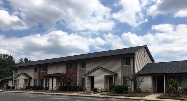 a building with a street in front of it and a cloudy sky