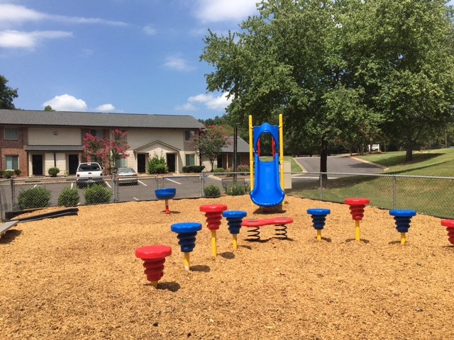 a playground with a blue slide and red and blue cones