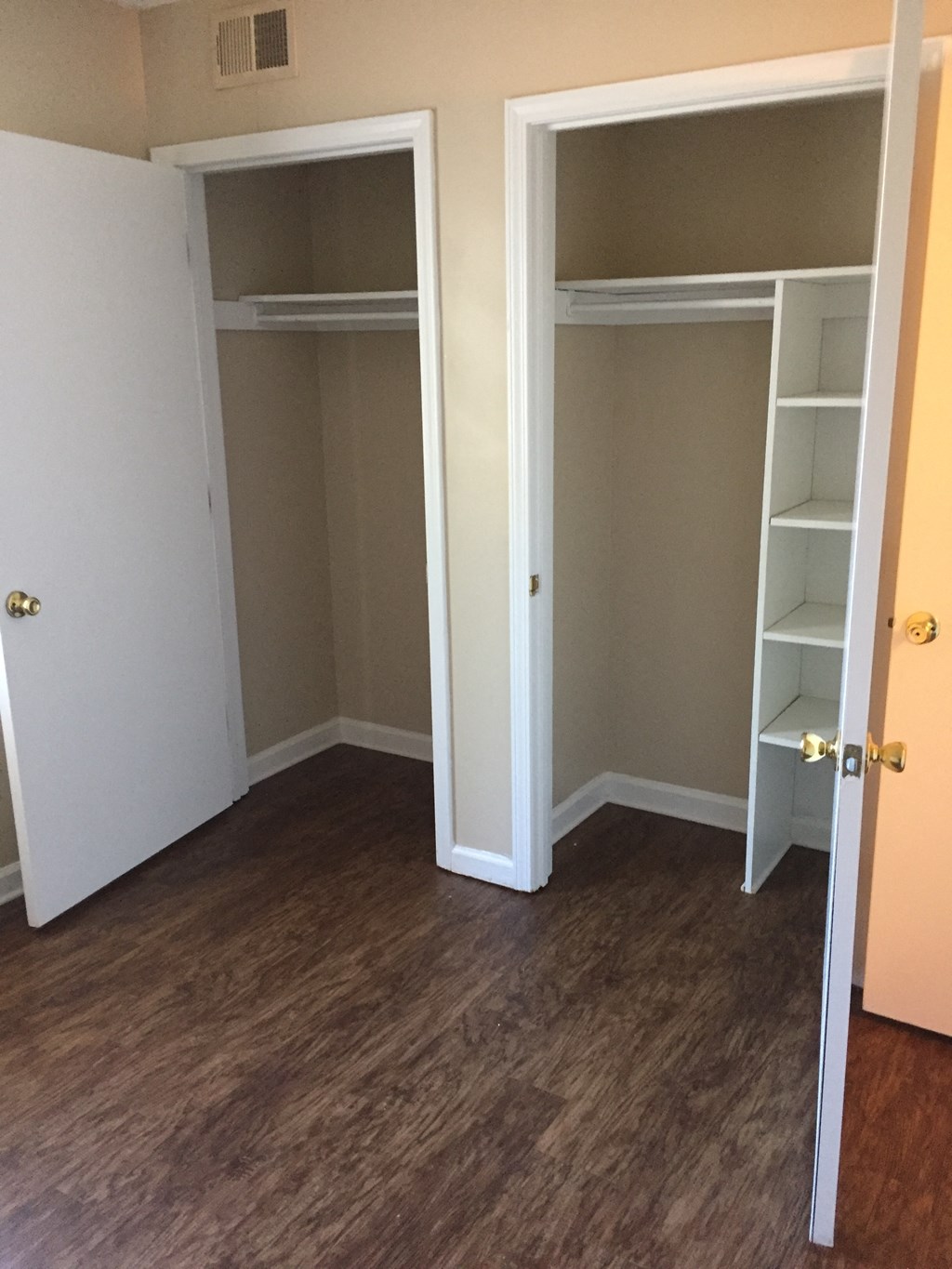 a room with a closet with shelves and a door