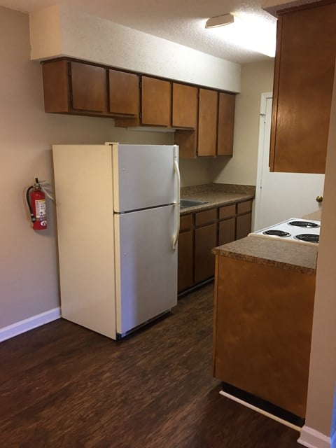 a kitchen with a refrigerator and a stove and cabinets