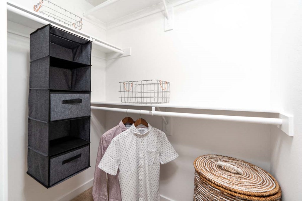 a small closet with white walls and a closet organizer