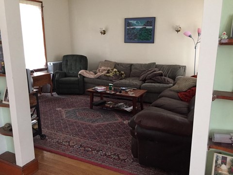 A living room with a grey couch and a green chair.