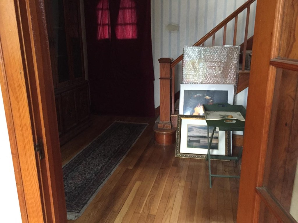 A room with wooden floors and a staircase.