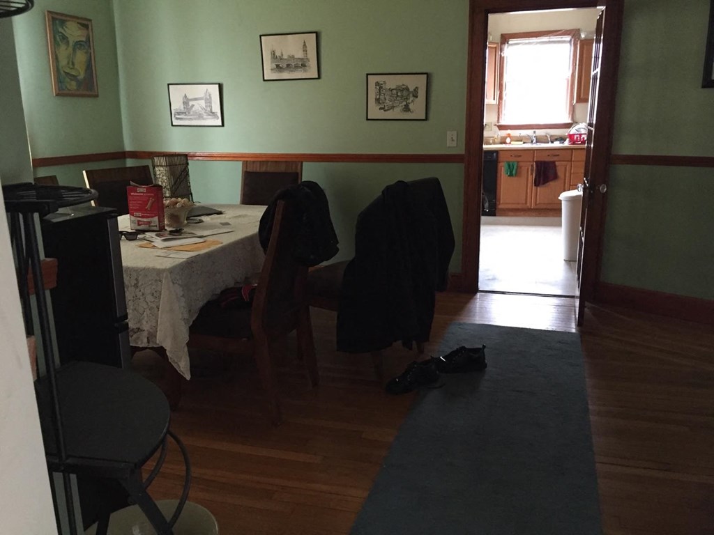 A room with a table and chairs and pictures on the wall.