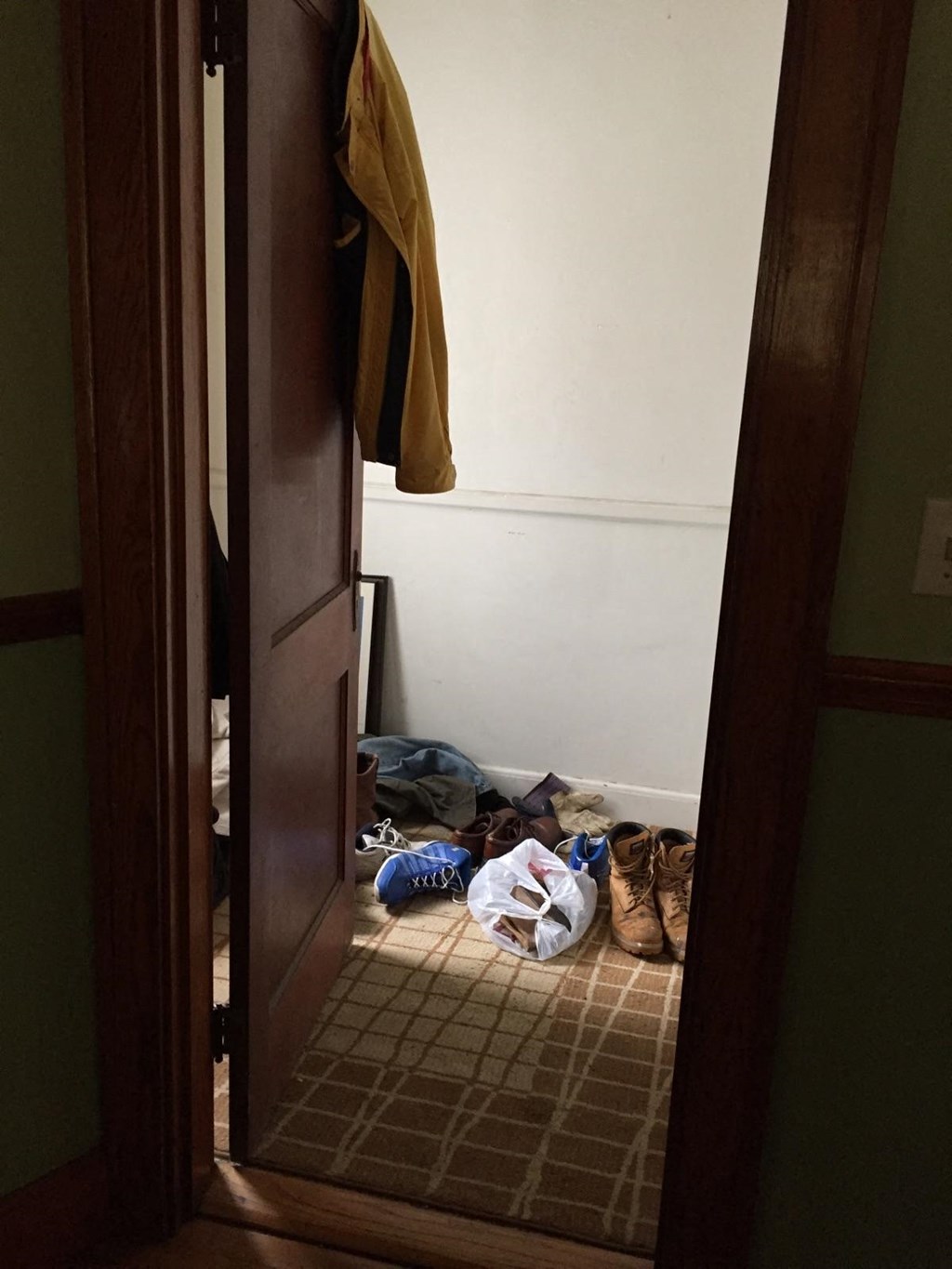 A pair of shoes are on the floor next to a door.