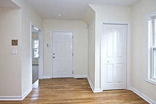 an empty living room with white walls and a wood floor