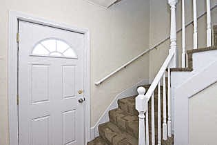 a white door in a stairwell next to a white staircase