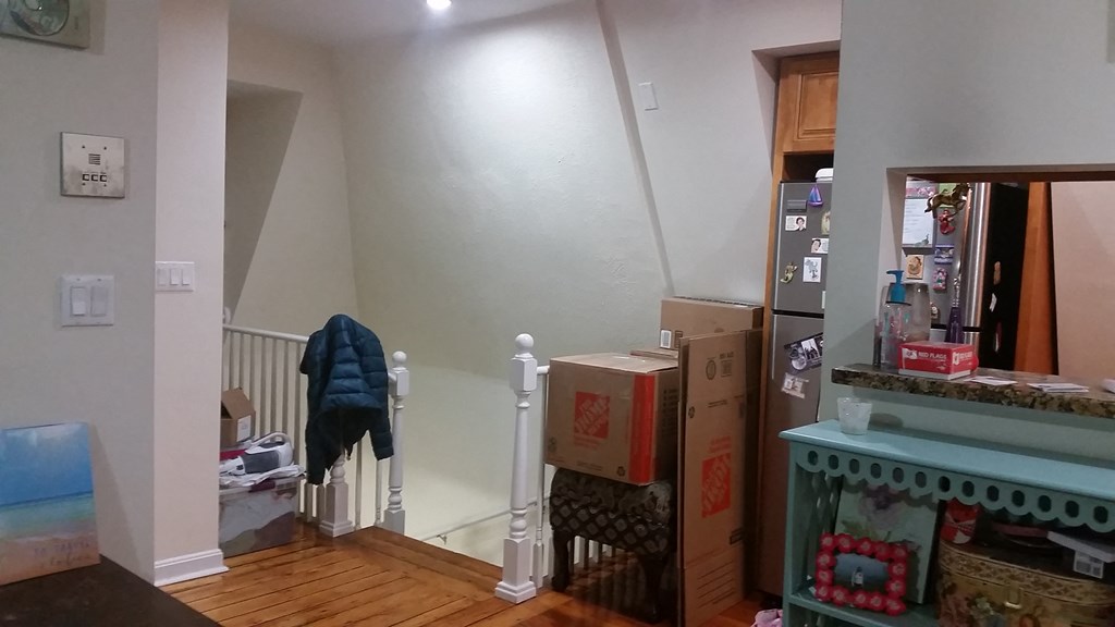 a man is standing on a staircase in a living room with boxes on the stairs