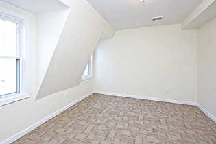 an empty room with a window and a tiled floor