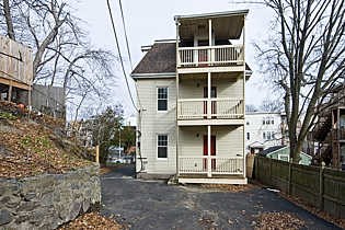 a white house with a balcony on a street