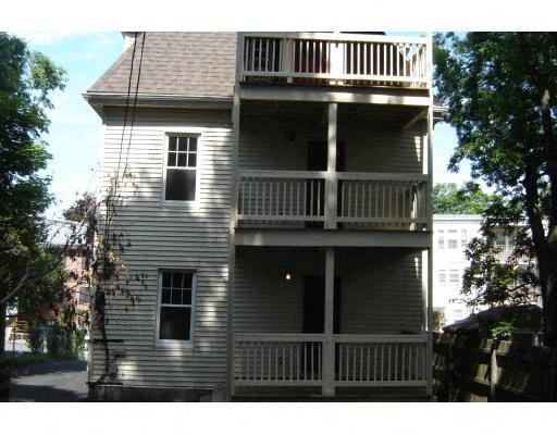 a white house with a balcony and trees
