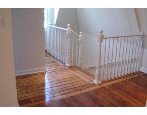 a staircase with a wood floor and a white railing