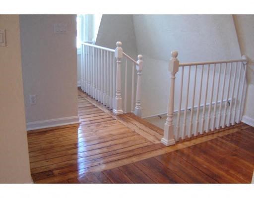 a staircase with a wood floor and white railing