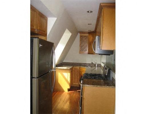 a kitchen with a stainless steel refrigerator and wooden cabinets