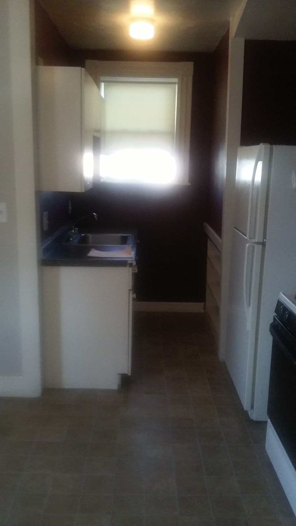 a kitchen with a sink and a refrigerator and a window