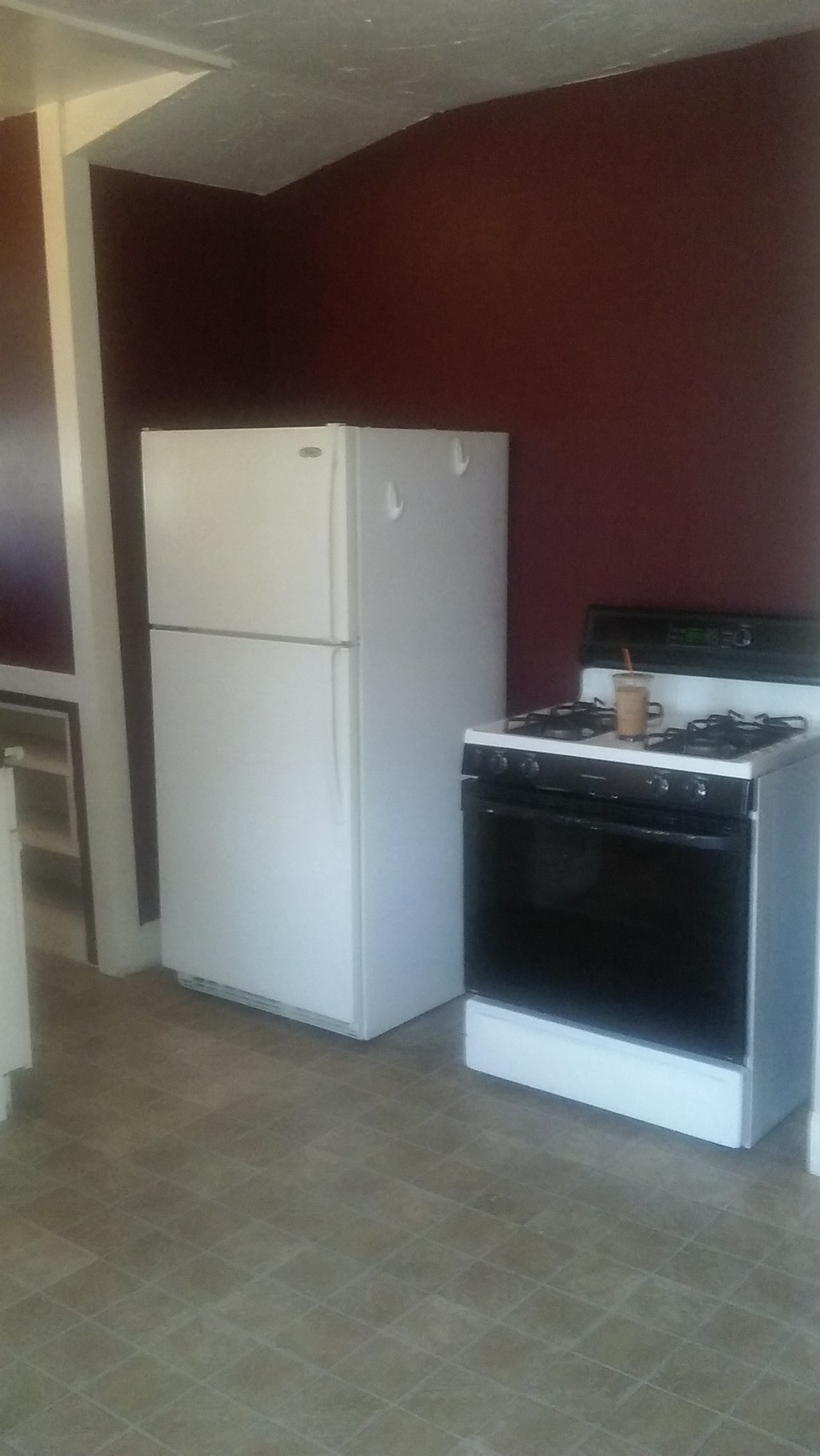 an empty kitchen with a stove and a refrigerator