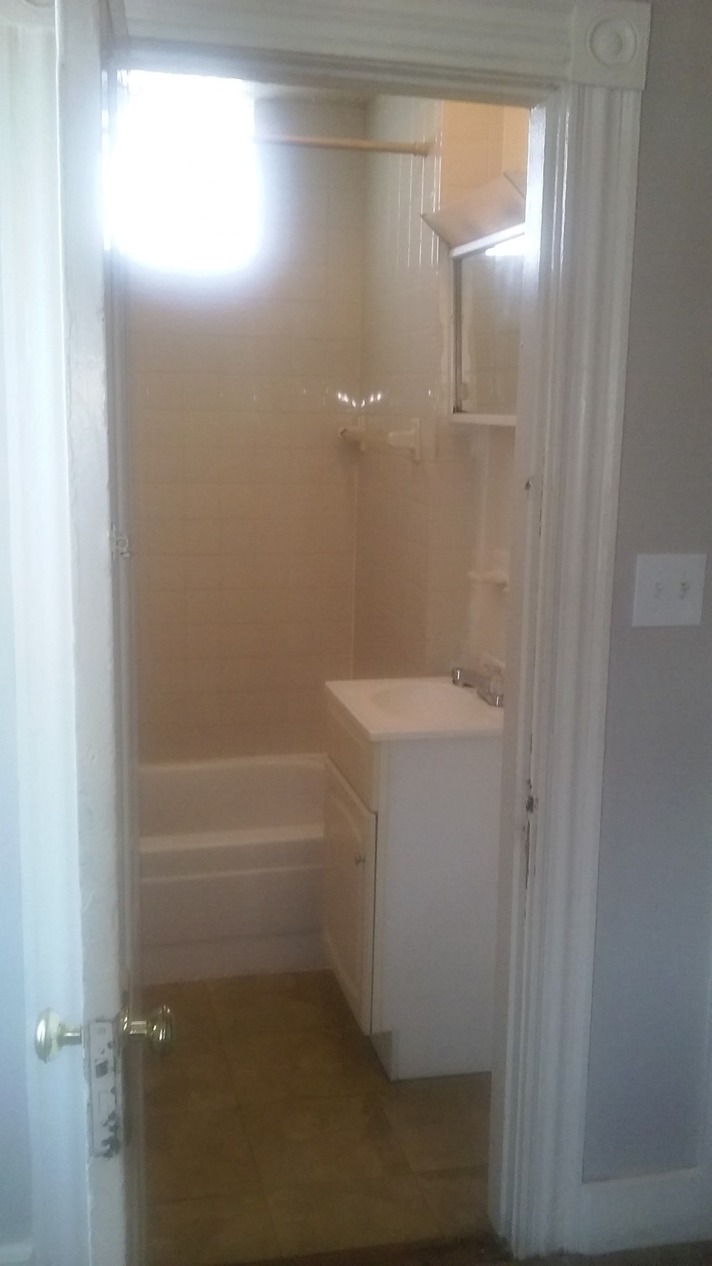 a white bathroom with a sink and a tub