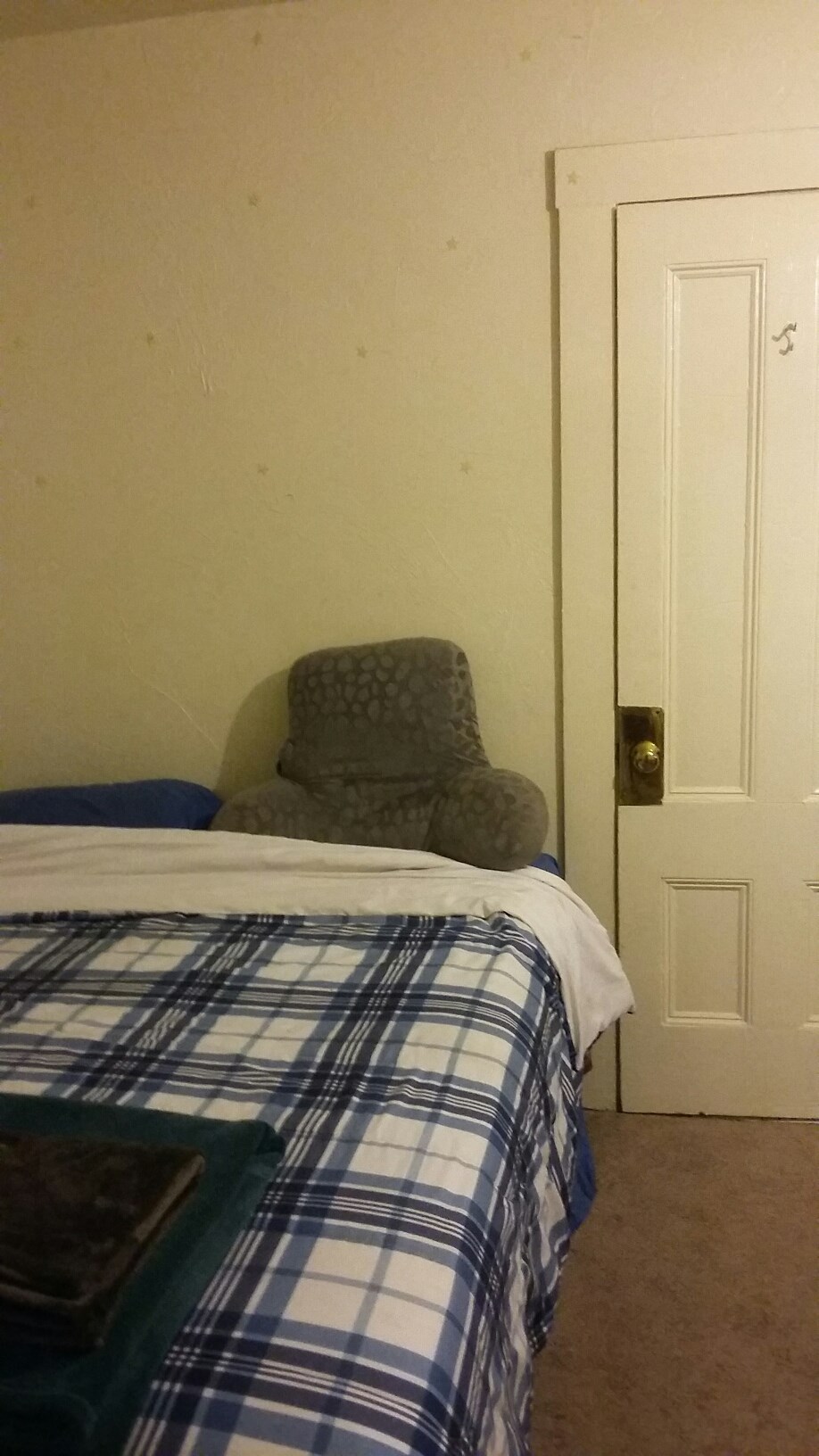 a small bedroom with a bed and a chair