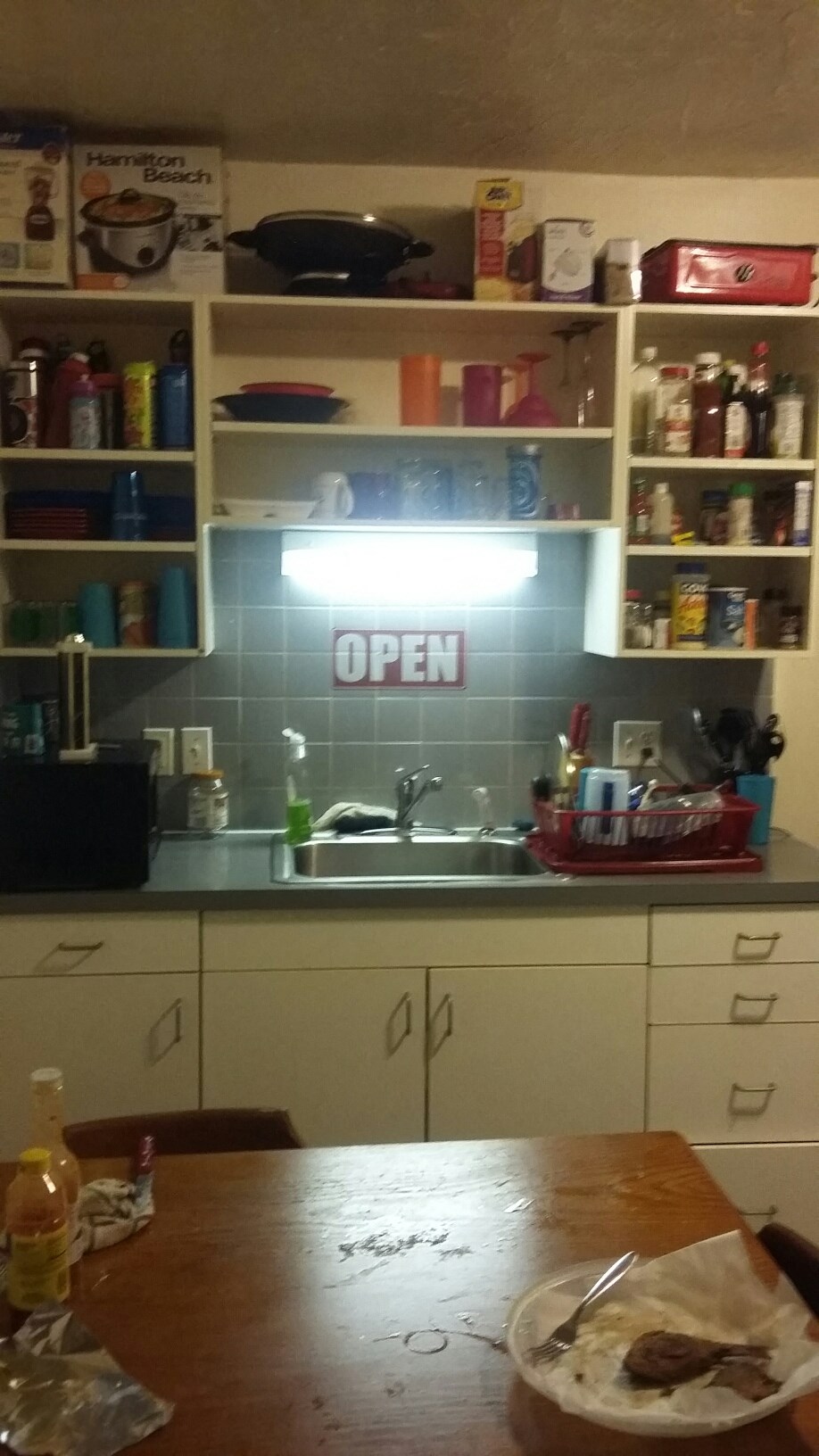 a kitchen with an open sign on the wall