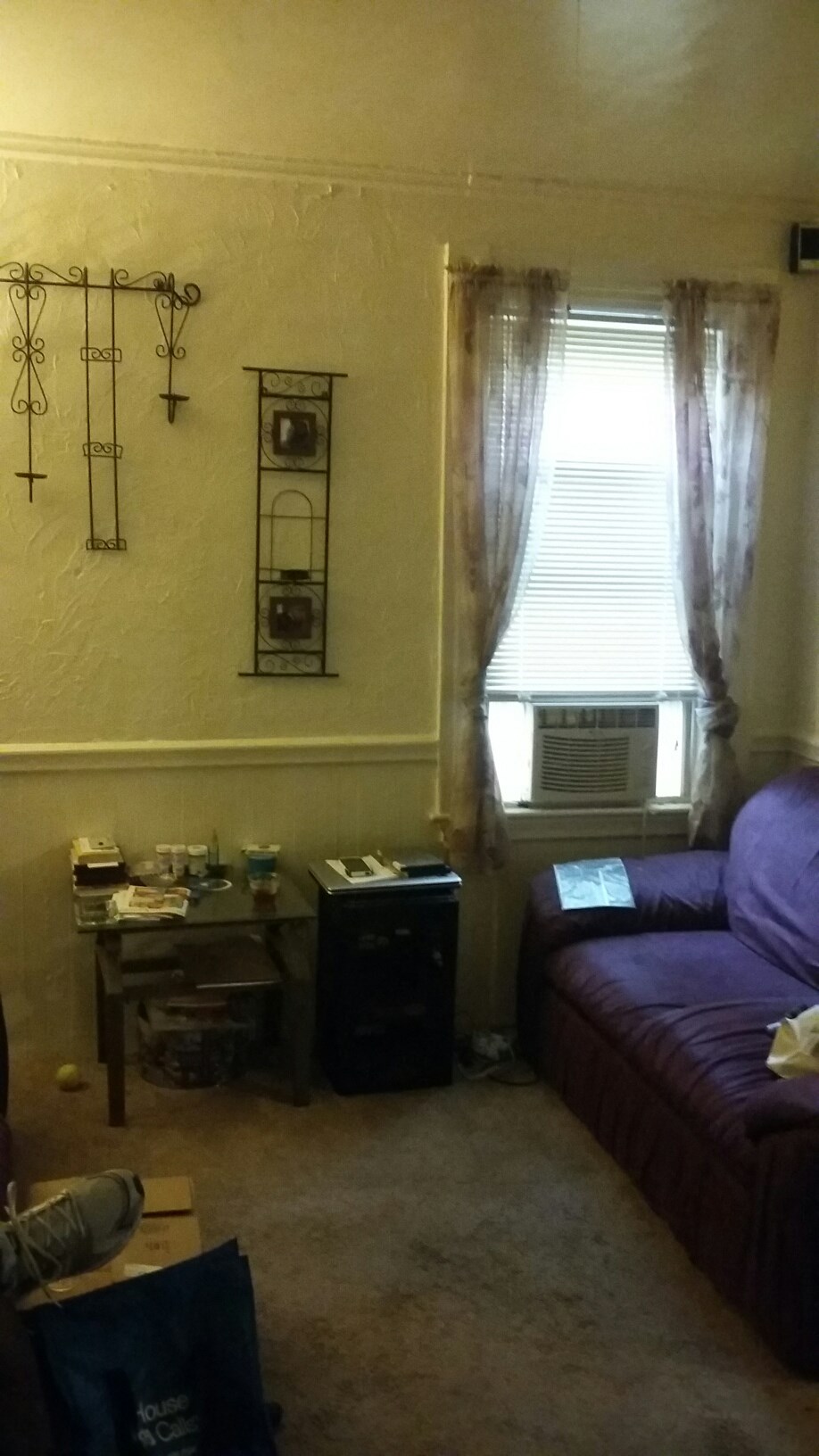 a living room with a purple couch and a window