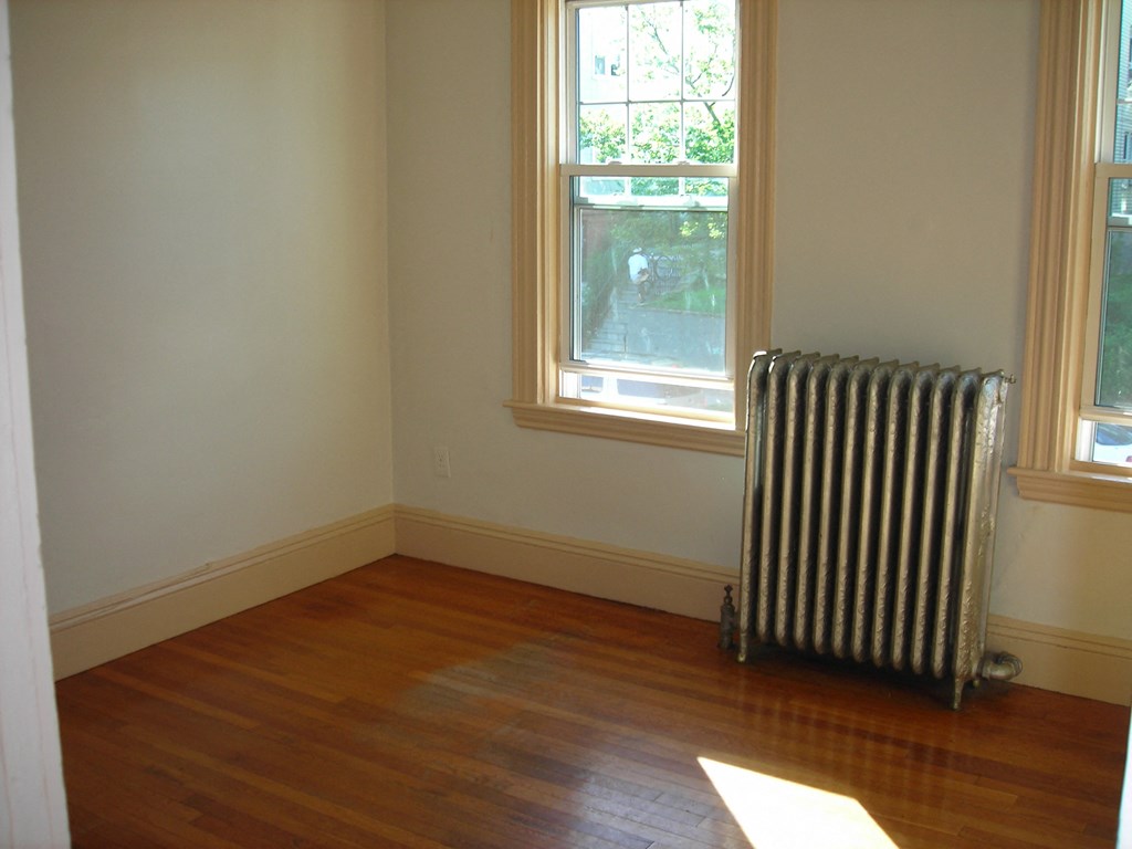 an empty room with a radiator and a window