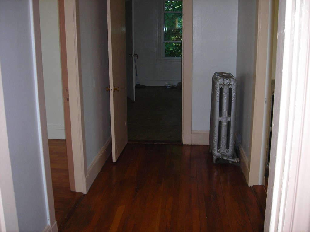 a room with a wood floor and an old radiator