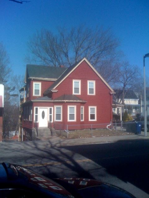 a large red house on the side of a street