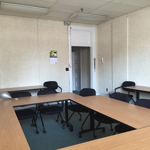 an empty conference room with desks and chairs