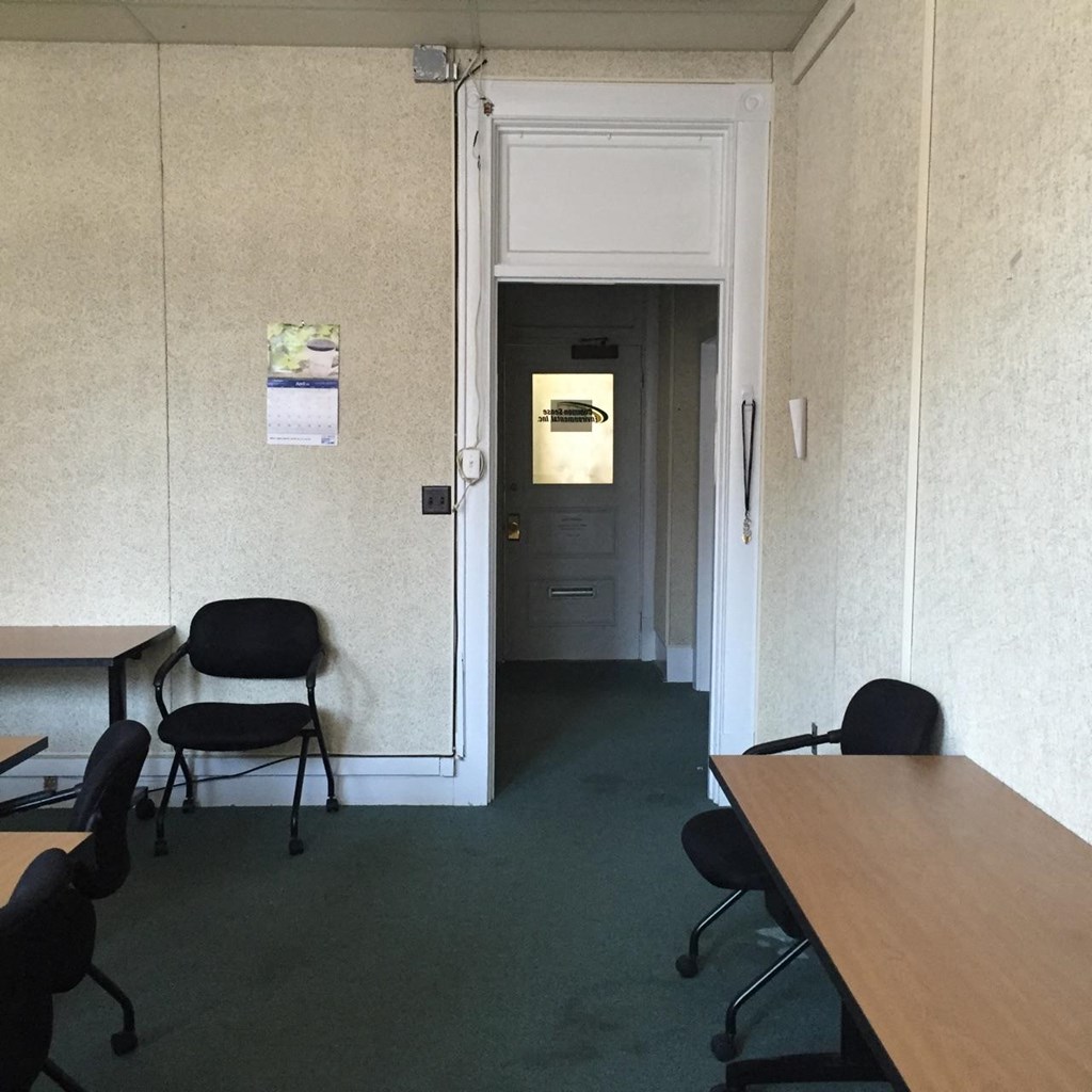 a room with desks and chairs and a door