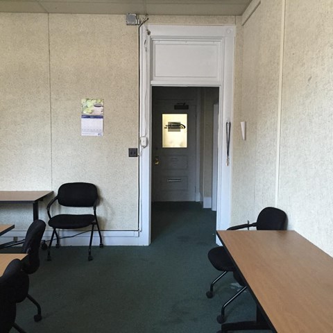 a room with desks and chairs and a door