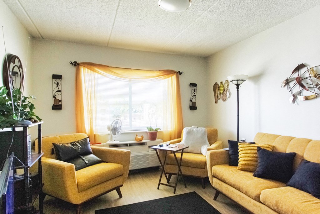 living room with model decor, large window, and wood-style flooring