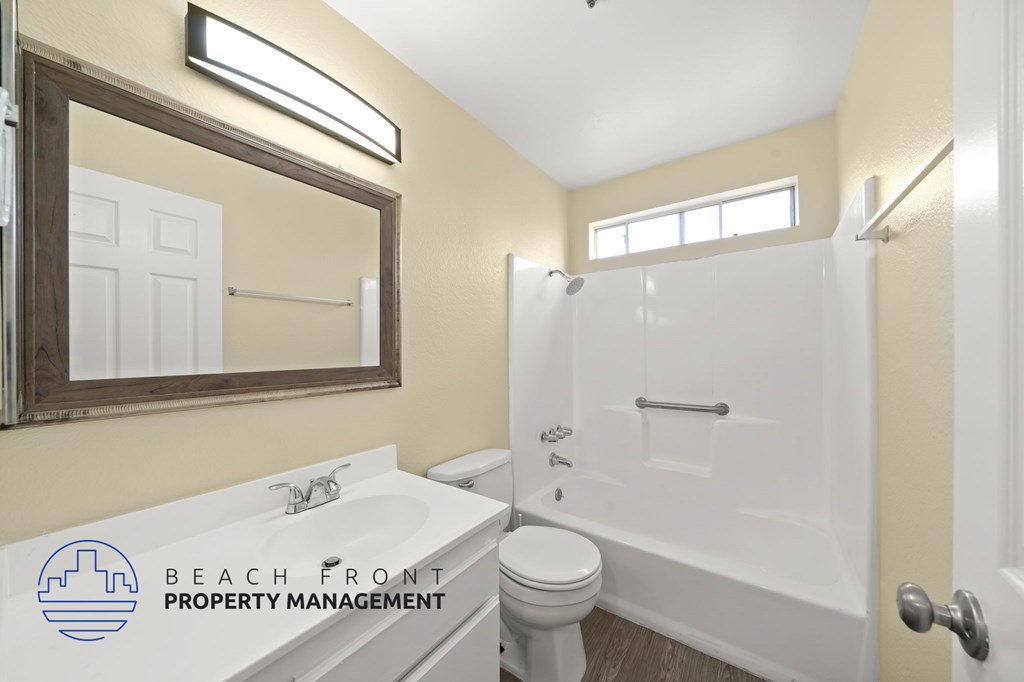 A bathroom with a toilet, sink, and bathtub.