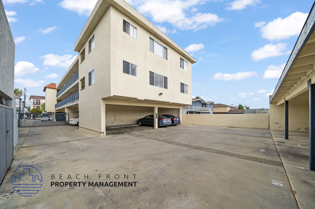 A two-story building with a parking lot in front of it.