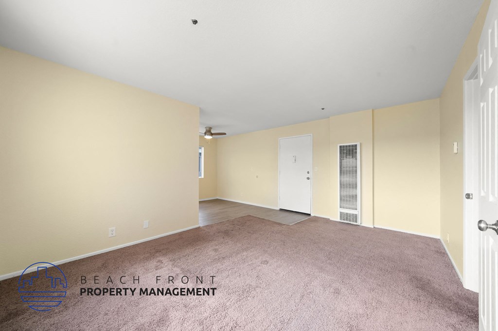 A room with a carpeted floor and a white door.