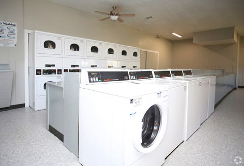 a group of washers and dryers in a laundry room