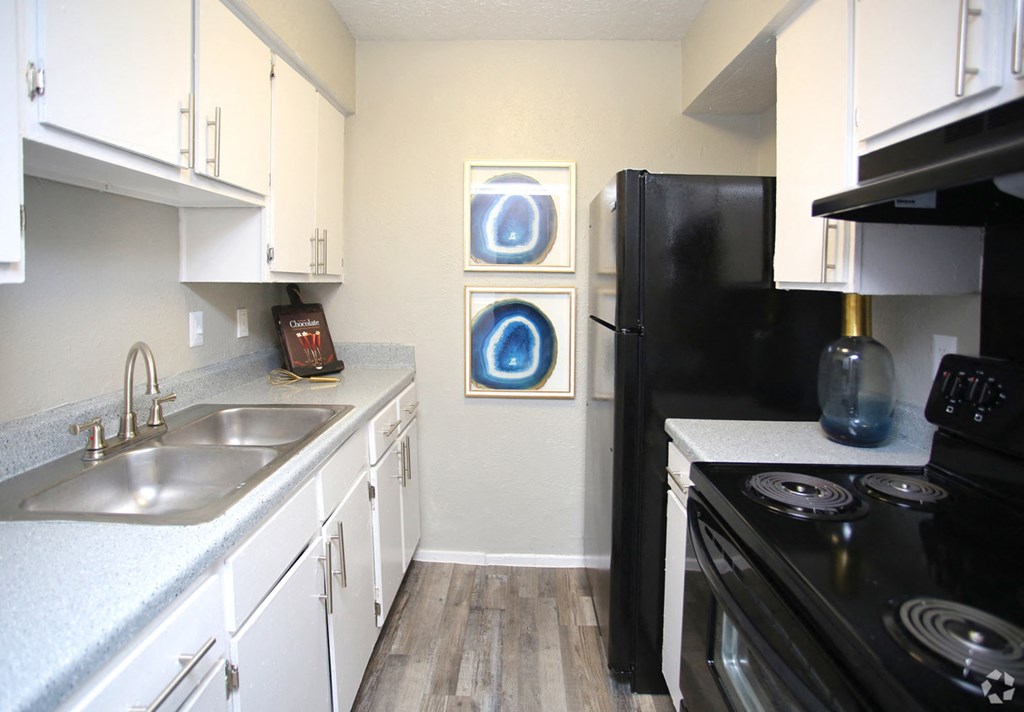a kitchen with black appliances and white cabinets