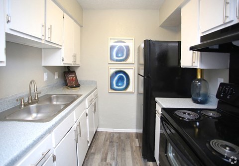 a kitchen with black appliances and white cabinets