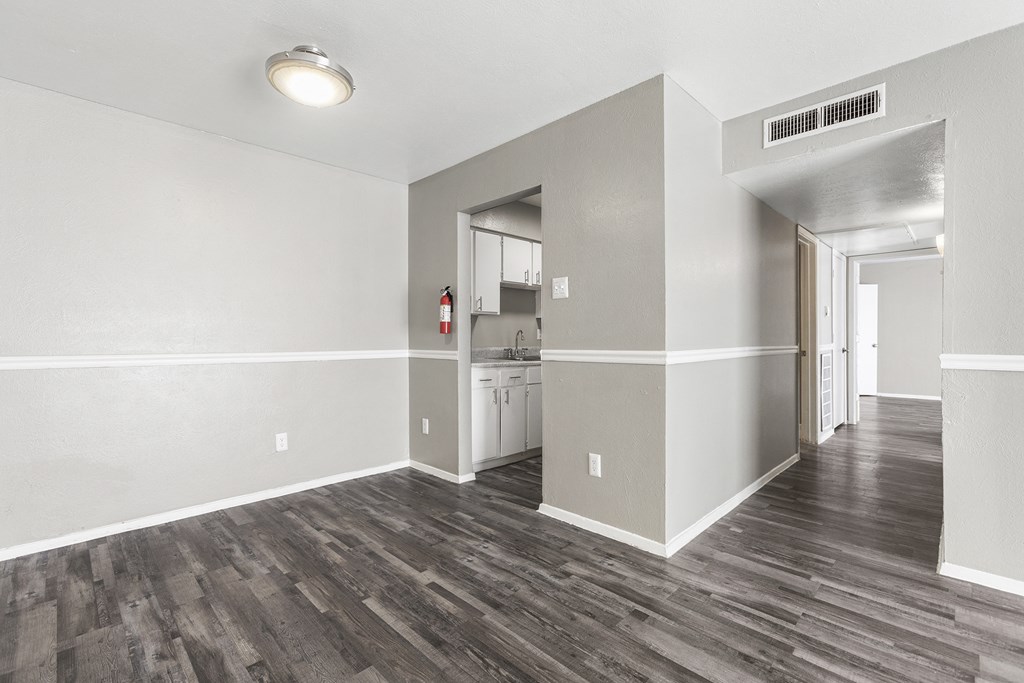 the living room and kitchen of an empty apartment