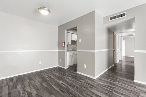 the living room and kitchen of an empty apartment