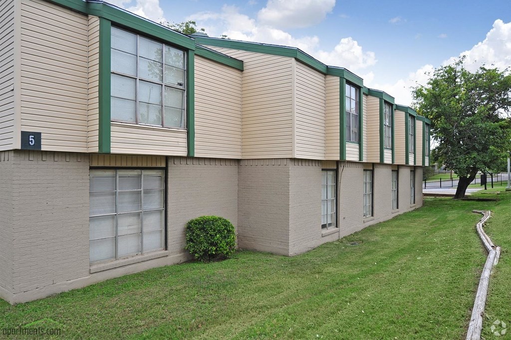 an apartment building with green and white windows on the side of it