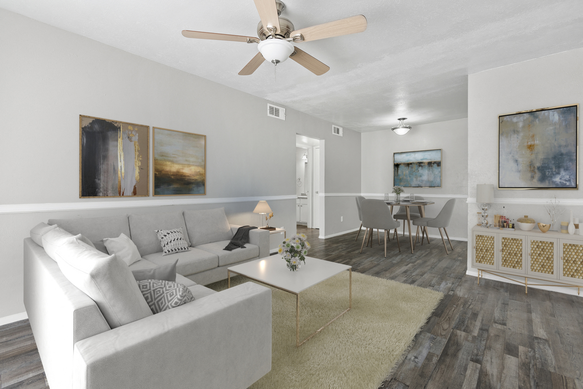 a living room with a couch and a table and a ceiling fan
