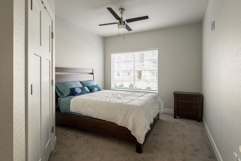 a bedroom with a bed and a ceiling fan