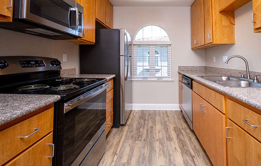 A kitchen with wooden cabinets and black appliances.